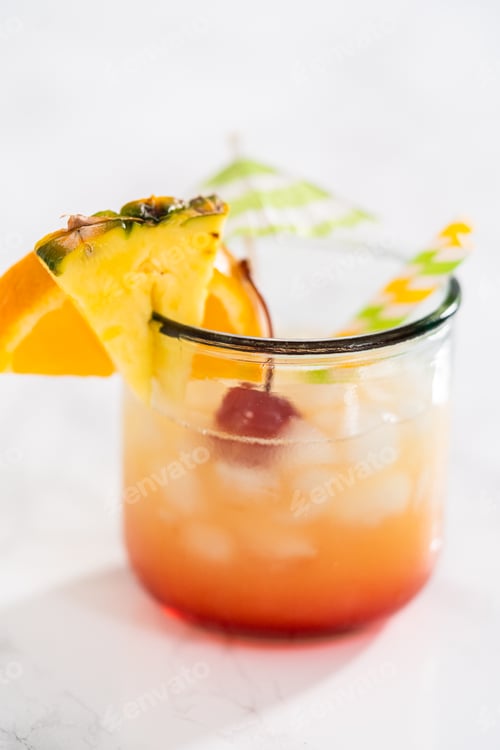 Bright Tropical Cocktail Garnished with Fruit and Umbrella