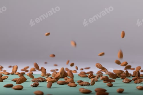 Preview: Almonds falling on table against gray background with copy space