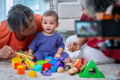 Preview: A man and a woman are playing with a baby and a bunch of toys. The baby is looking at the camera and