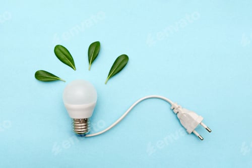 Preview: LED light bulb with power plug and green leaves on blue background representing eco-friendly energy