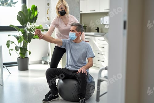Preview: Female physical therapist working with senior man