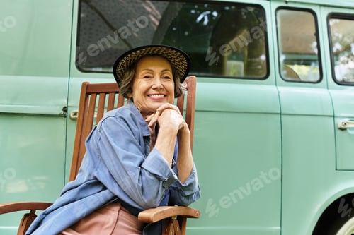 Preview: Senior woman enjoys peaceful moments in her beautiful garden on a sunny afternoon