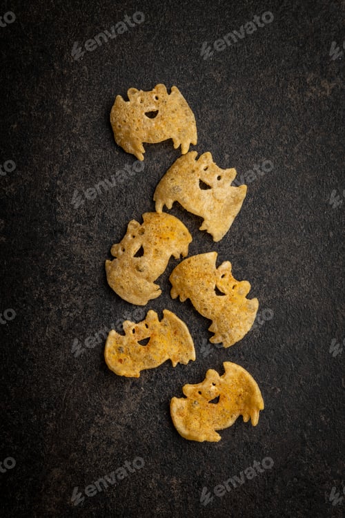 Preview: Halloween crispy bat shaped chips on dark table.