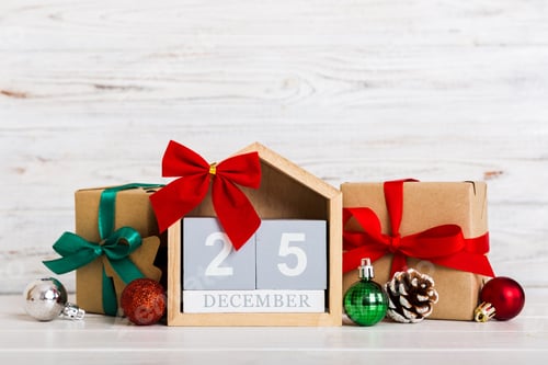 Preview: 25 december. Christmas composition on colored background with a wooden calendar, with a gift box
