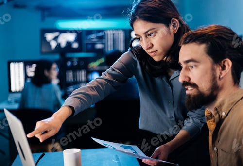 Preview: Stock trader team looking and analyzing stock data on laptop