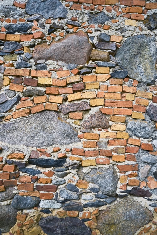 Preview: Old brick wall with cobblestones, grunge background. Copy space. Vertical
