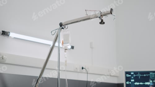 Preview: Close up of IV drip bag and empty hospital ward bed