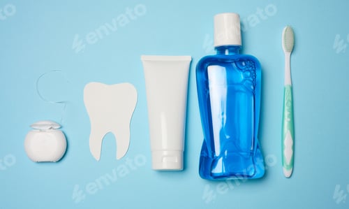 Preview: Mouthwash, toothpaste tube, dental floss on a blue background, oral hygiene