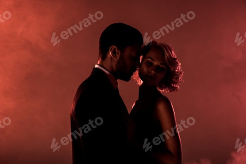 Preview: Attractive tender couple of young adults on red smoke background