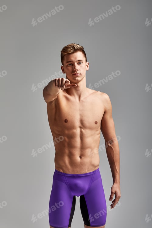Preview: A swimmer, a young athlete in excellent physical shape, shows with his hand urging to start training