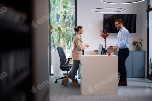 Preview: Happy colleagues communicating while working at corporate office.