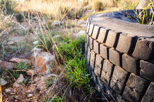 Preview: Old wheels of unrecycled cars thrown in a natural field pollute the earth.