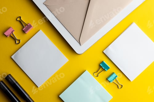 Preview: Flat lay of black pens, envelope and white paper with copy space on yellow background
