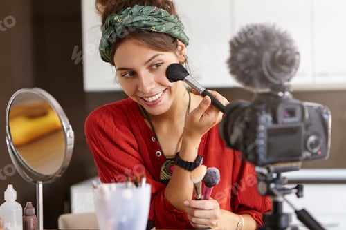 Preview: Candid shot of cute young Caucasian woman blogger presenting beauty products and broadcasting live v
