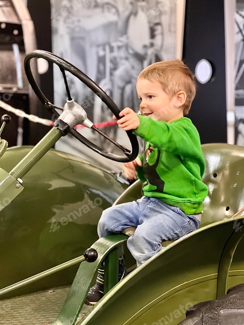 Preview: A little boy driving a retro tractor