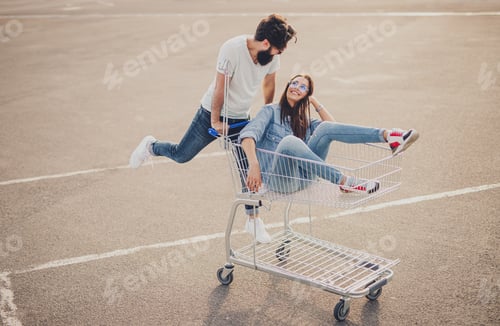 Preview: Happy couple riding shopping trolley