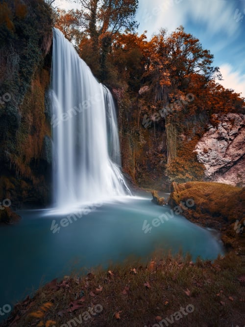 Preview: Vertical shot of a scenic waterfall and autumnal plants