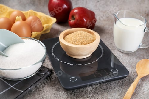 Preview: Digital kitchen scale with bowl of brown sugar and other products on grey table, closeup