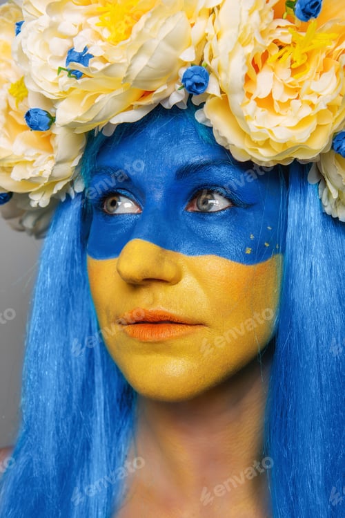 Preview: Creative close-up portrait of young woman with yellow blue face art. Concept for Flag Day in Ukraine