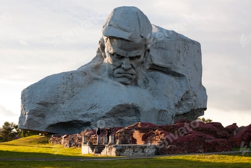 Preview: Giant stone head monument with visitors at its base.