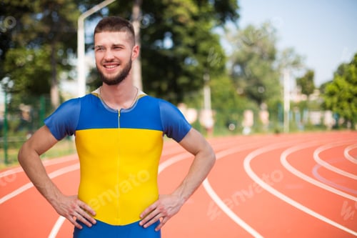 Preview: Young professional sportsman happily looking aside while spending time on treadmill of stadium
