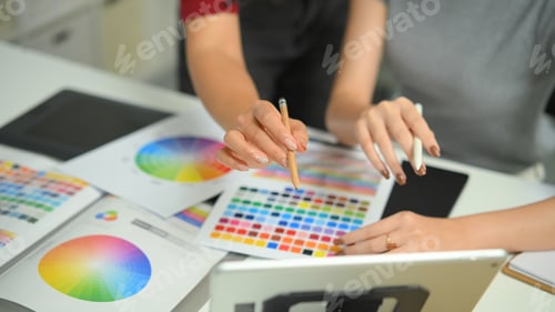 Preview: Cropped shot two graphic design desk sharing idea and creative with color on the desk