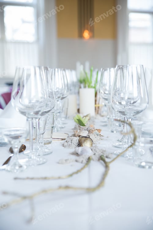 Preview: Vertical shot of a dining table with wine glasses and plates