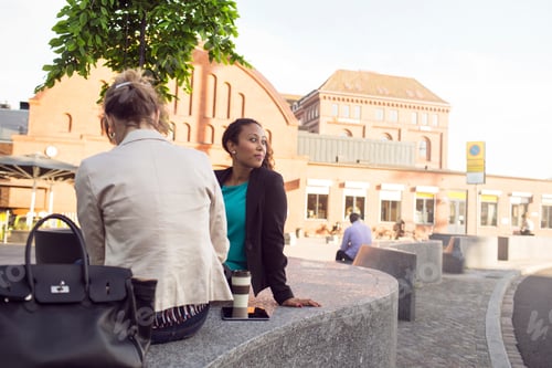 Preview: Two friends enjoying a sunny day in the city square.