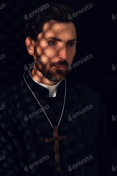Preview: Catholic priest wearing cassock in confessional booth