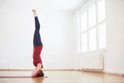 Preview: Woman in exercise studio doing headstand