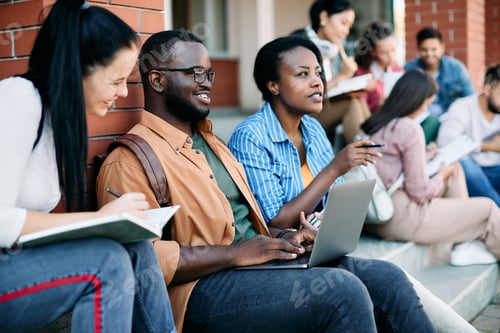 Preview: Happy black student using laptop while learning with his friends at campus.