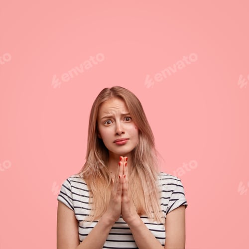 Preview: Please, forgive! Lovely Caucasian female with appealing look, keeps palms pressed together, asks God