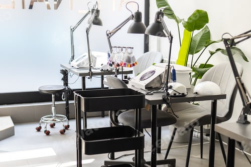 Preview: Modern table with nails color palette and lamp situating in salon. Workplace for manicure. Interior
