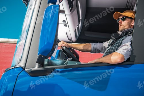 Preview: Truck Driver in Blue Vehicle During Sunny Day Near Red Building in Urban Area