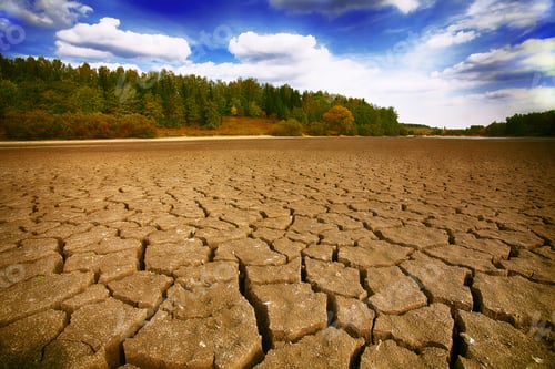 Preview: Dry Cracked Earth Under Blue Cloudy Sky