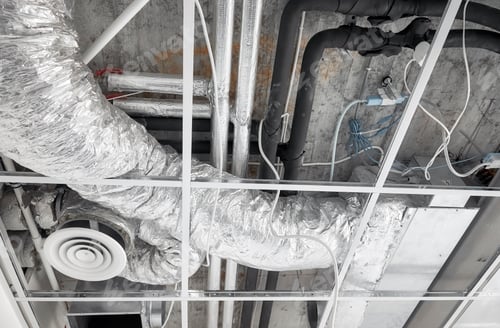 Preview: Ventilation system with pipes in silver insulation material in suspended ceiling during renovation.