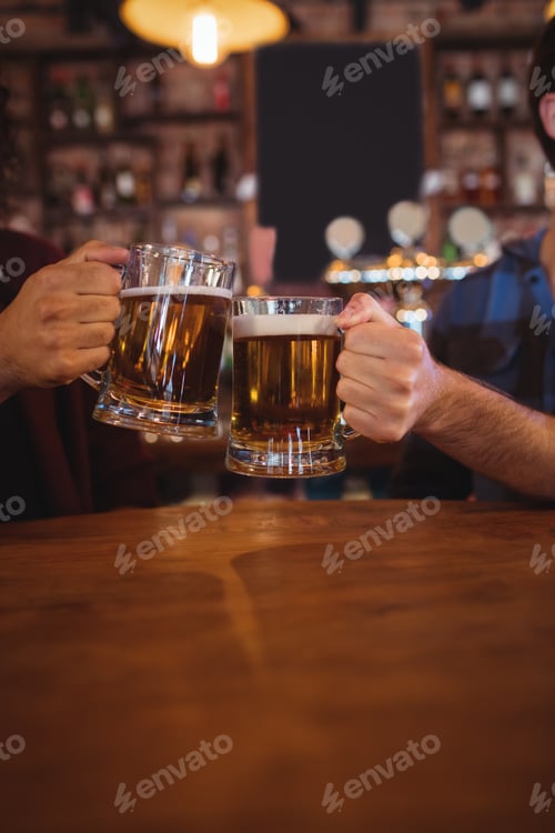 Preview: Two young men toasting their beer mugs