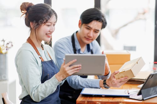 Preview: Startup small business SME. Two Young Asian business entrepreneurs using laptop computer check onlin