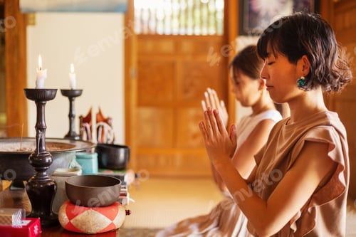 Preview: Two Japanese women kneeling in Buddhist temple, praying.
