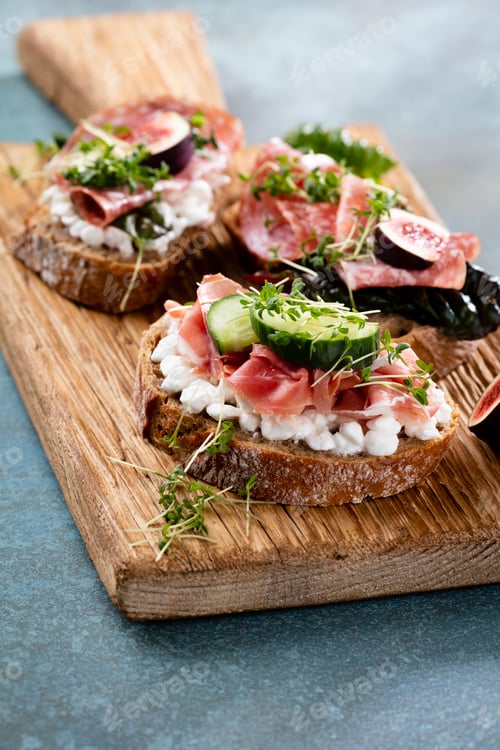 Vorschau: Verschiedene Mini-Sandwiches mit Frischkäse, Gemüse und Salami.
