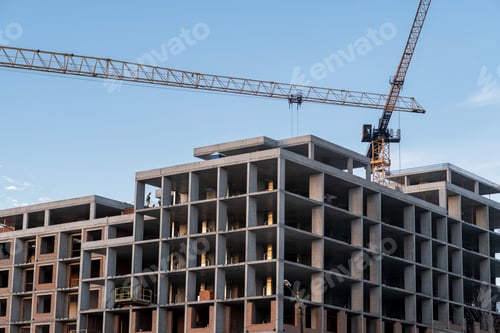 Preview: crane and a building under construction against a blue sky background