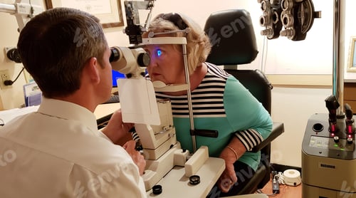 Preview: Womens health at optometrist checking eyeballs for glaucoma in vision test with instrumentation.