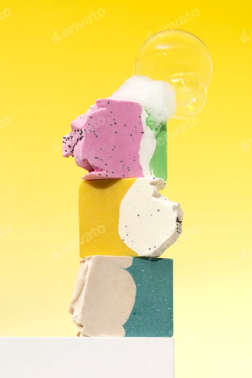 Preview: Natural handmade soap. Bright pieces of soap with soap bubbles on a pedestal on a yellow.