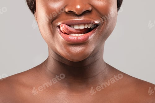 Preview: Cropped Image Of Naked Black Female Playfully Biting Her Tongue And Smiling