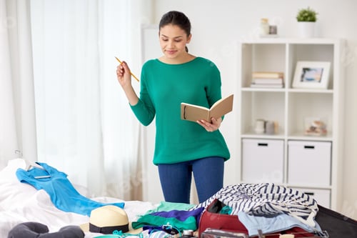 Preview: woman with notebook planning her trip at home
