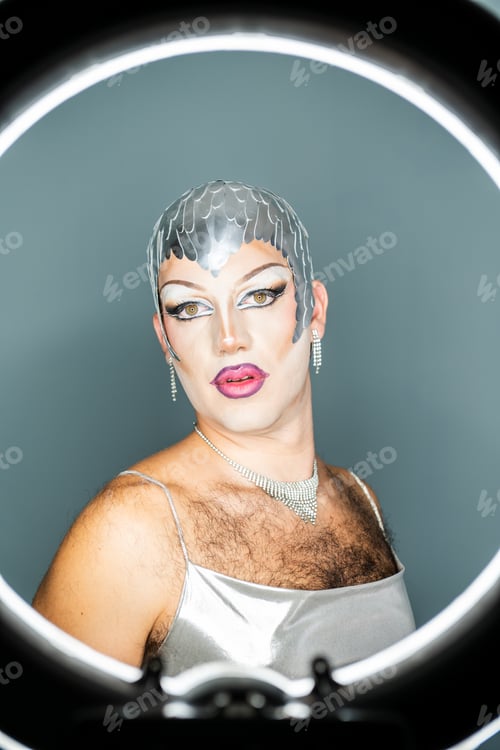 Preview: Portrait of a Latin Drag Queen Posing in Front of a Ring Light With a Striking Makeup Look