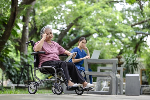 Preview: Elderly woman in a wheelchair showing signs of discomfort or stress