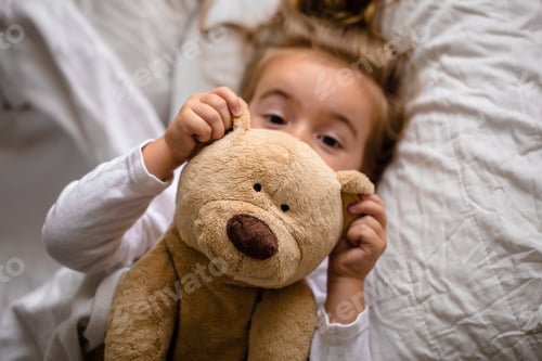 Preview: little girl in bed with soft toy the emotions of a child