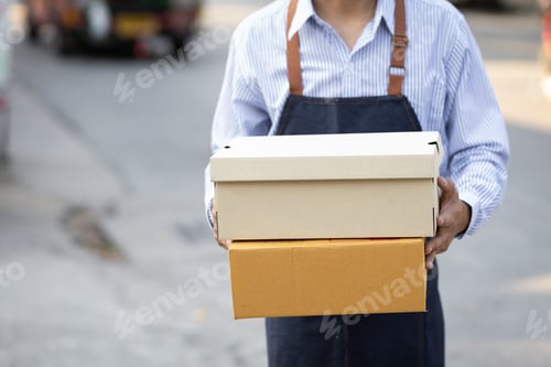 Preview: Close-up, the delivery man holding the parcel is handing it to the recipient.