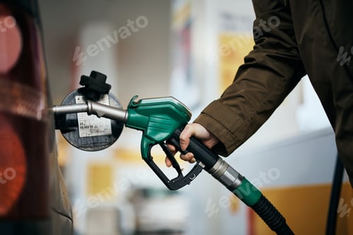 Preview: Close-up of woman filling car fuel tank at gas pump.